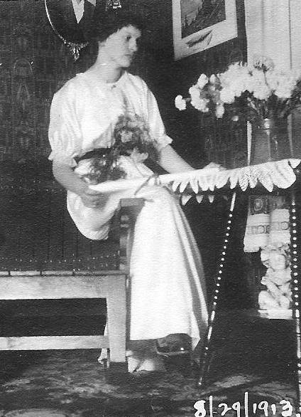 A photograph of a woman in a white dress. At the bottom, the date "8/29/1913" is written.